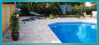 interlocking stone tile deck surrounding in-ground pool